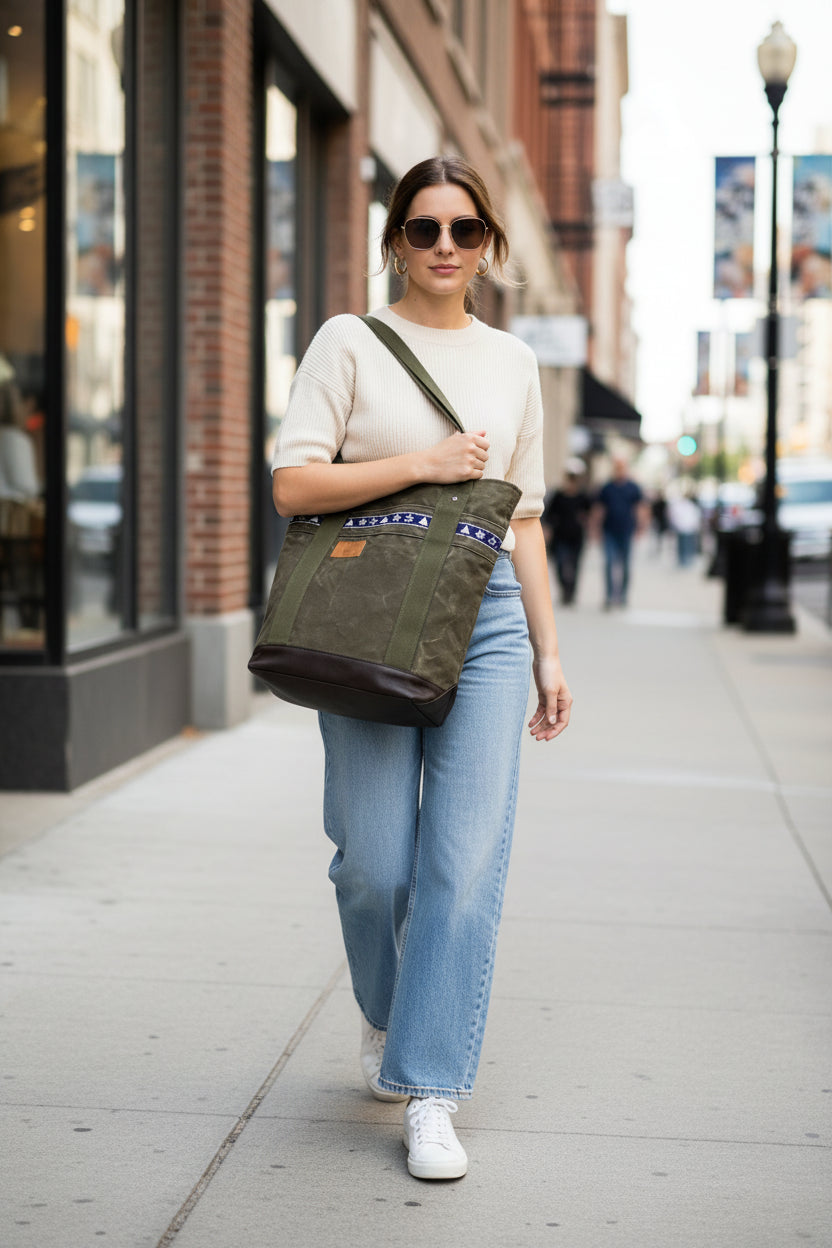 Umhängetasche - Einzelstück aus recyceltem Seesack in grün mit maritimem Design und Lederbesatz in Braun, von einer Frau getragen.